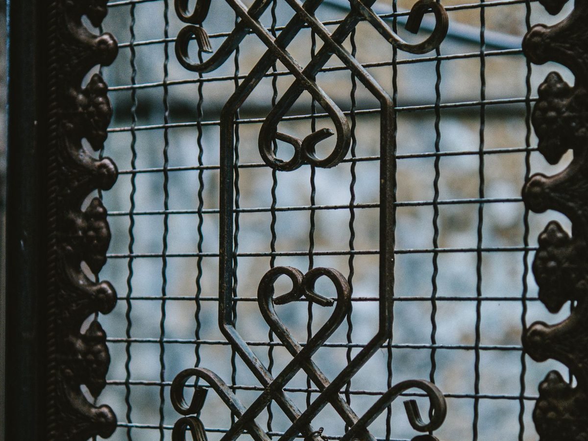 A decorative mild-steel window grille with scrollwork.